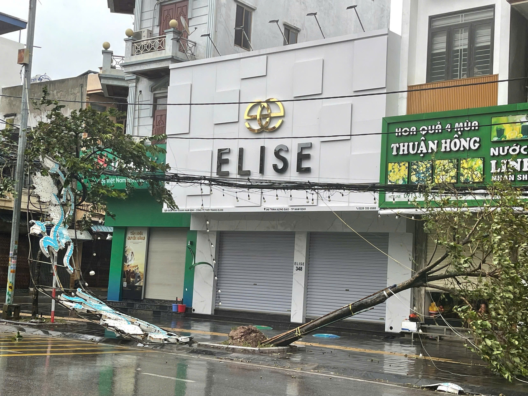 Nhiều biển quảng cáo bị gió quật đổ, cây xanh đổ ngổn ngang, kéo theo cả dây điện và đường dây thông tin ở thành phố Nam Định.