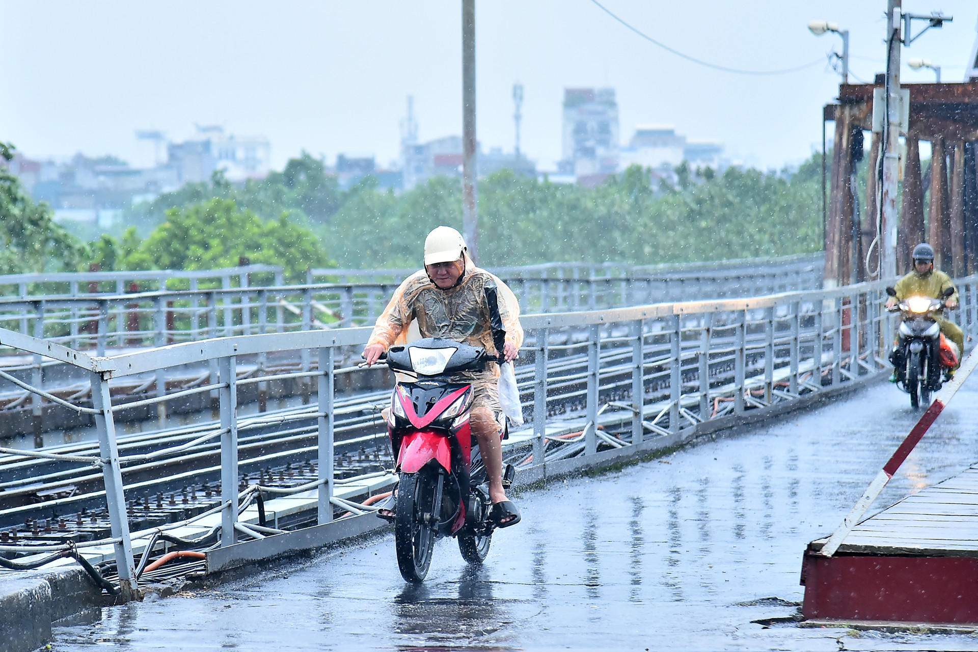 Người dân di chuyển qua khu vực cầu Long Biên gặp rất nhiều khó khăn do ảnh hưởng của gió mạnh. (Ảnh: THỦY NGUYÊN)