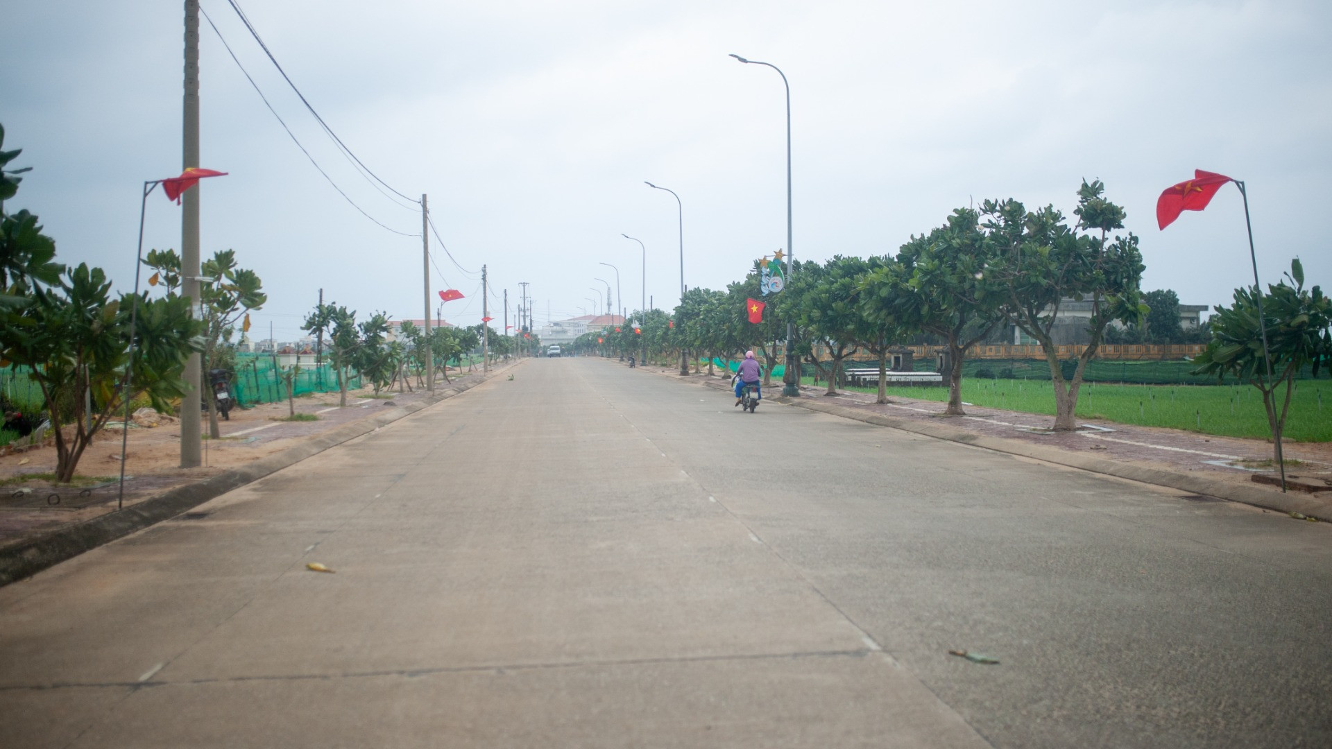 Đặt chân lên đảo, chúng tôi tiến vào trung tâm huyện đảo trên con đường bê-tông trải dài thênh thang. Hai bên đường cờ đỏ sao vàng bay phấp phới, cạnh đó là hàng cây bàng vuông và cánh đồng tỏi, hành xanh mướt.