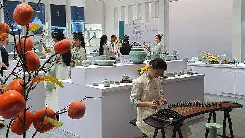 Gian hàng gốm sứ Trung Quốc với trình diễn đàn tranh và cổ phục.