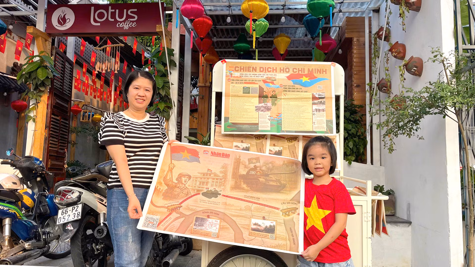 Hai mẹ con vui mừng chụp ảnh lưu niệm khi có được tờ phụ san. (Ảnh: HỮU NGHĨA)