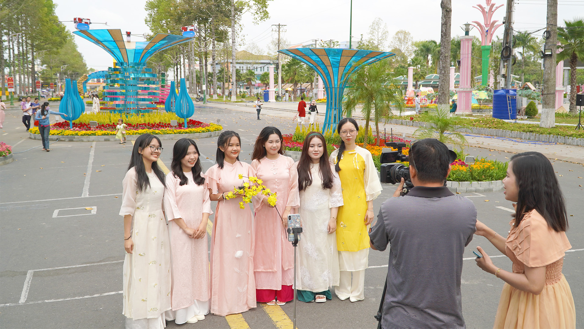 Một nhóm bạn trẻ đến tham quan đường hoa bày tỏ bất ngờ và phấn khởi khi được 2 phóng viên Truyền hình Đồng Tháp đưa vào "khung hình", góp phần làm cho không khí đường hoa thêm sinh động. (Ảnh: HỮU NGHĨA)