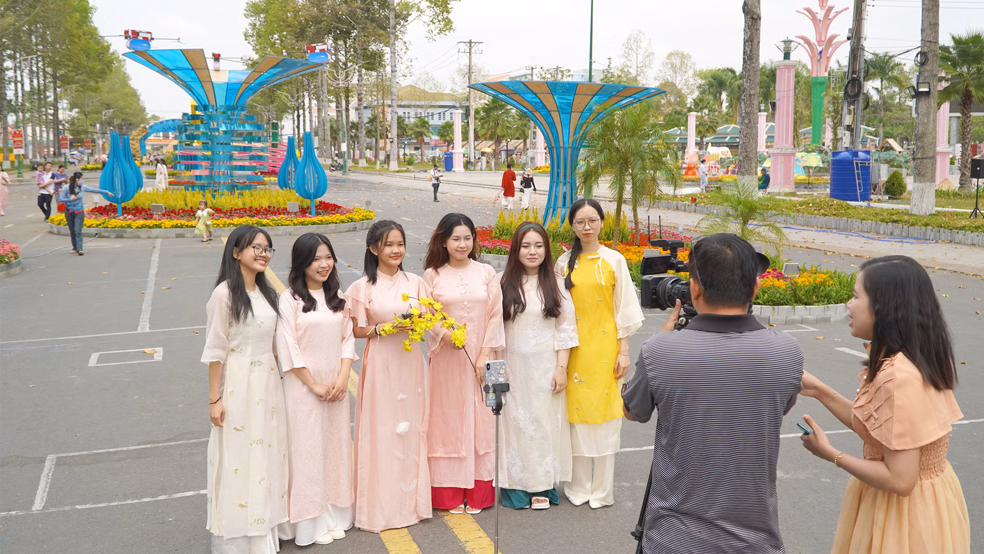 Một nhóm bạn trẻ đến tham quan đường hoa bày tỏ bất ngờ và phấn khởi khi được 2 phóng viên Truyền hình Đồng Tháp đưa vào "khung hình", góp phần làm cho không khí đường hoa thêm sinh động. (Ảnh: HỮU NGHĨA)