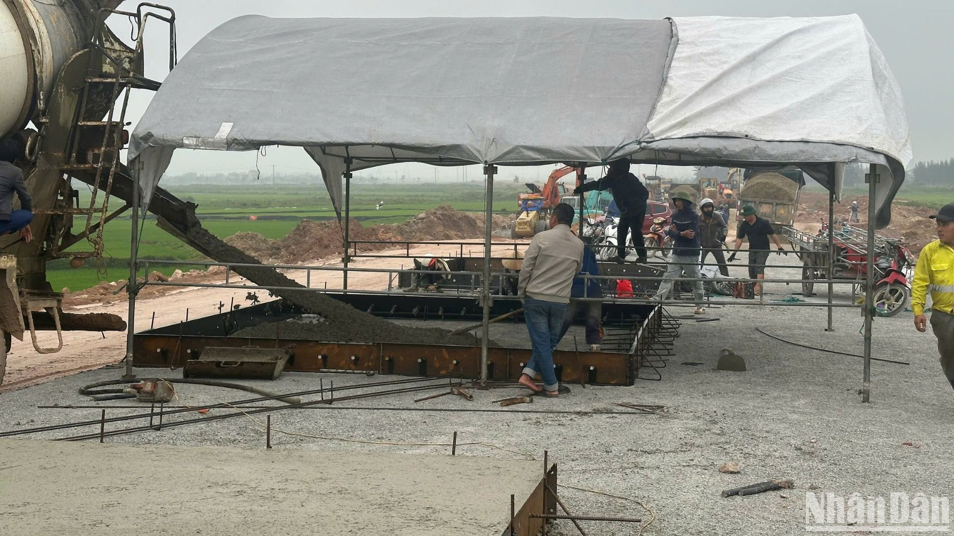 Nhà thầu căng bạt vào những hôm trời mưa để không lỡ tiến độ công trình khi đổ các tấm bê-tông phục vụ dự án.