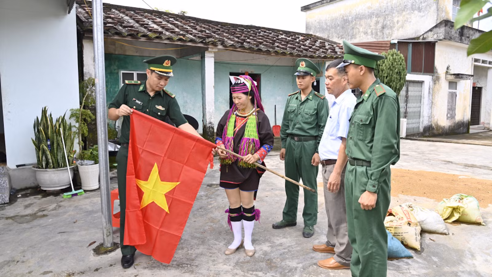 Cán bộ, chiến sĩ Đồn Biên phòng Pò Hèn tặng cờ Tổ quốc cho người dân xã Hải Sơn.