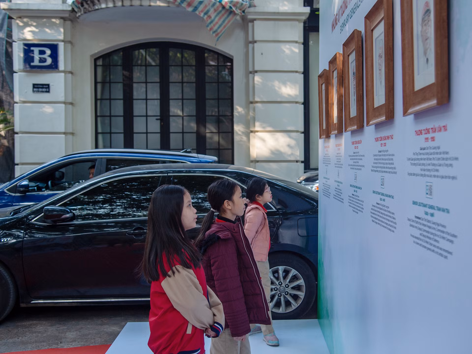 Các em học sinh lớp 3B tìm hiểu về 20 vị tướng tài danh của Quân đội nhân dân Việt Nam do họa sĩ Đỗ Hoàng Tường thực hiện bằng kỹ thuật màu nước trên chất liệu giấy bản tại triển lãm.