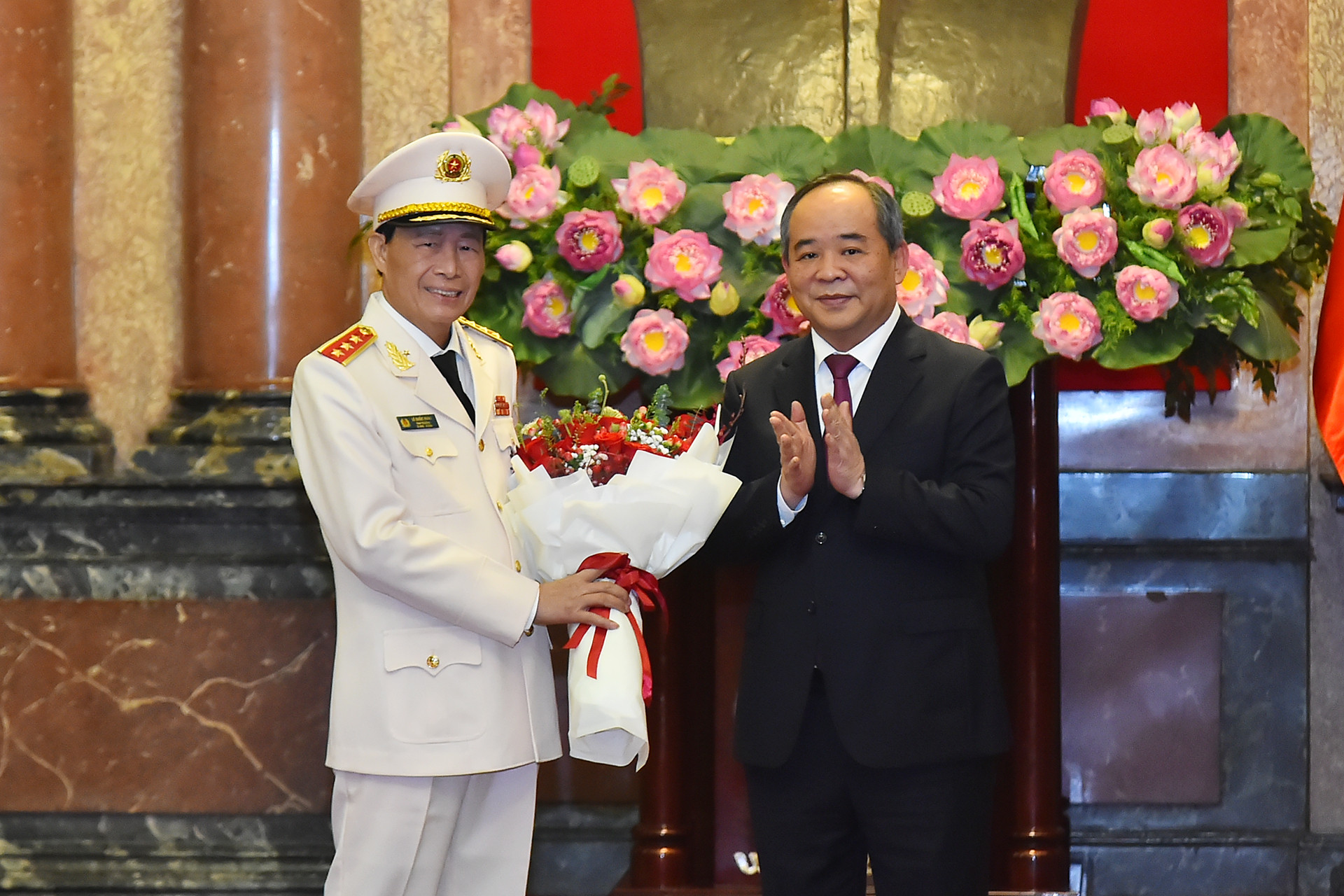 Chủ nhiệm Văn phòng Chủ tịch nước Lê Khánh Hải tặng hoa chúc mừng Thượng tướng Lê Quốc Hùng.