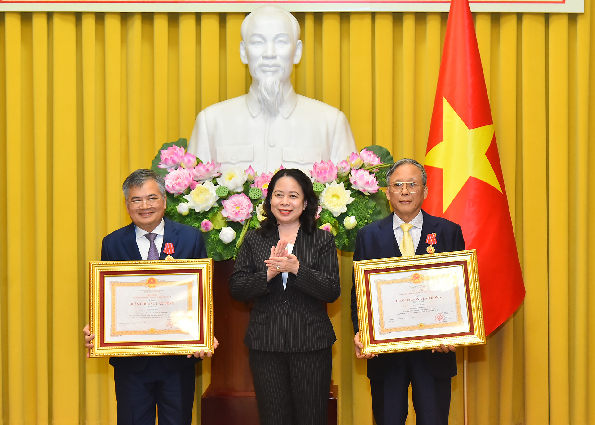 Phó Chủ tịch nước Võ Thị Ánh Xuân trao Huân chương Lao động hạng Nhất tặng đồng chí Bùi Huy Hùng (bên phải) và Huân chương Lao động hạng Nhì tặng đồng chí Cấn Đình Tài (bên trái).