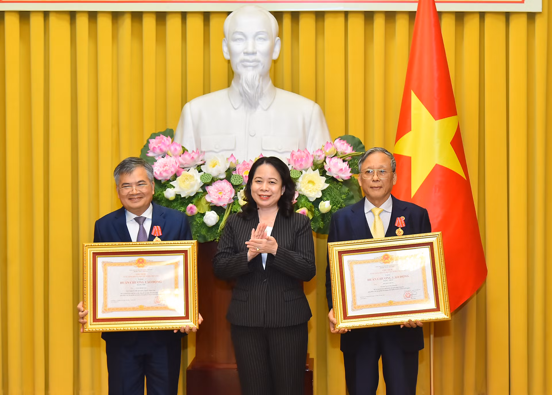 Phó Chủ tịch nước Võ Thị Ánh Xuân trao Huân chương Lao động hạng Nhất tặng đồng chí Bùi Huy Hùng (bên phải) và Huân chương Lao động hạng Nhì tặng đồng chí Cấn Đình Tài (bên trái).