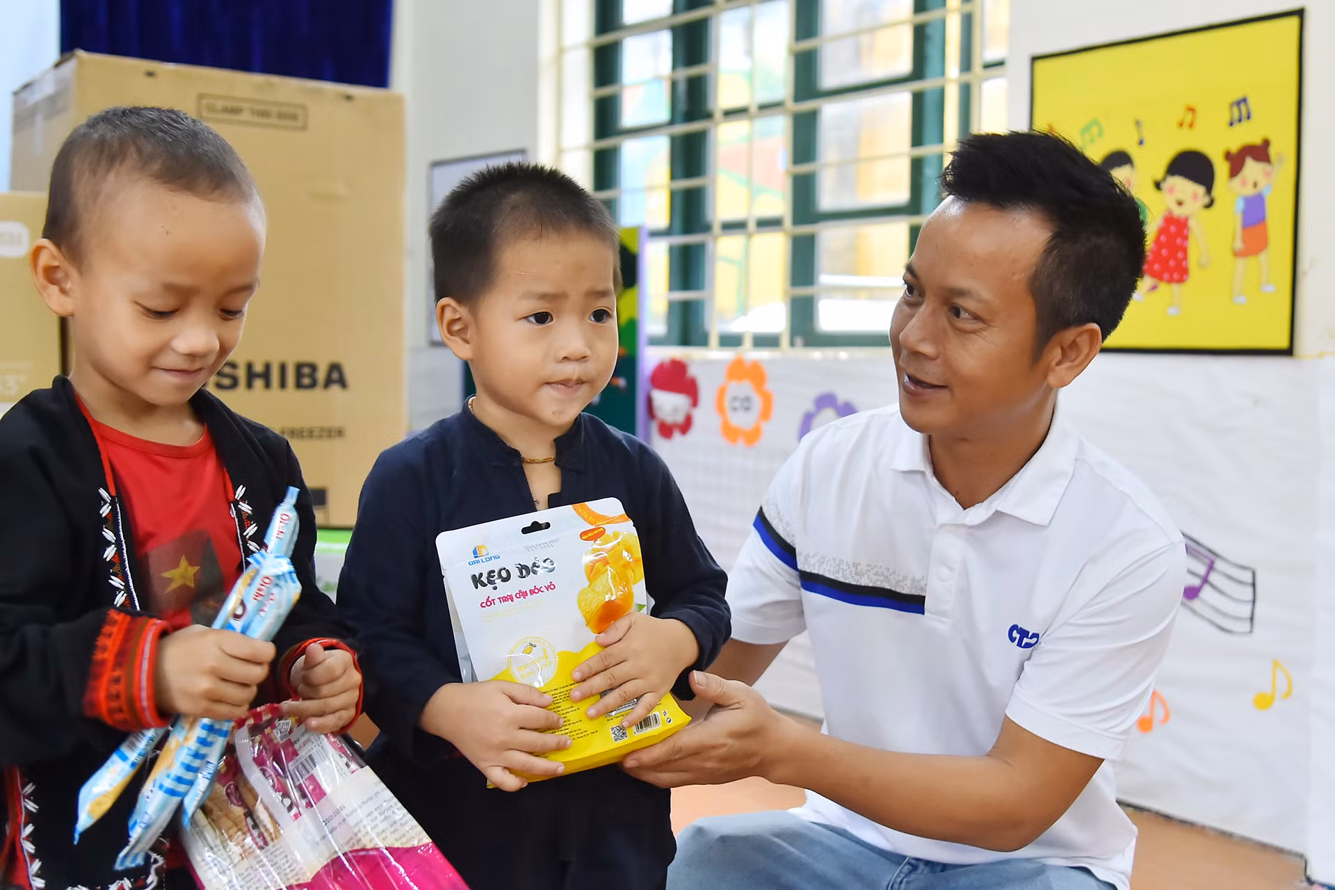 Đại diện Công ty Cổ phần Đầu tư xây dựng CTA Việt Nam trao quà, tặng các em học sinh Trường mầm non Hợp Thành.