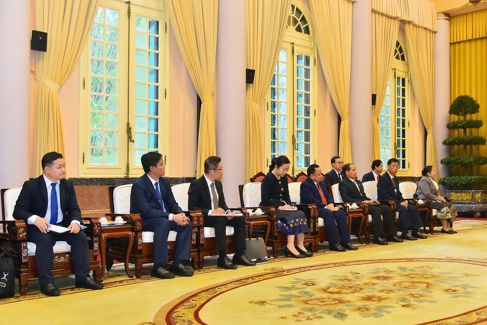 Các đại biểu tháp tùng Thường trực Ban Bí thư, Phó Chủ tịch nước Lào Bounthong Chitmany tham dự buổi tiếp.