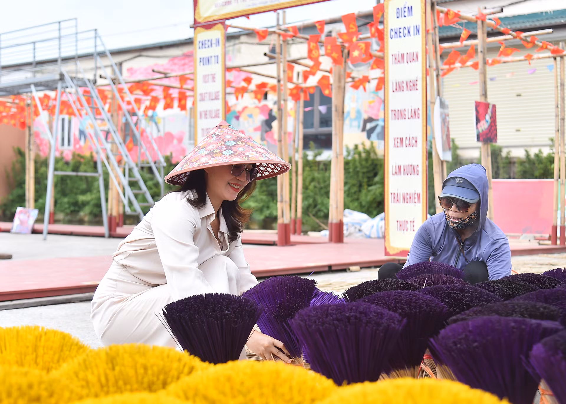 Du khách trải nghiệm hoạt động phơi hương tại điểm check-in làng hương Quảng Phú Cầu.