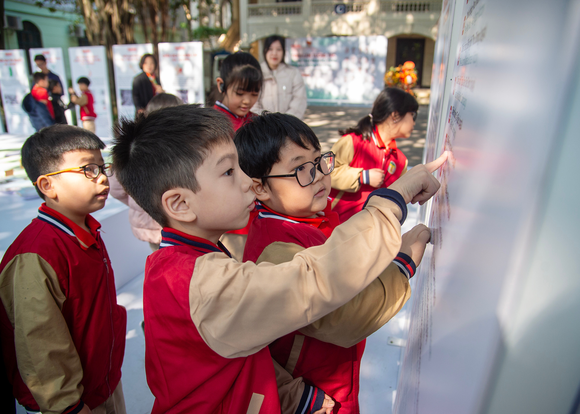 Các em học sinh Trường tiểu học Tràng An tìm hiểu về lịch sử Quân đội nhân dân Việt Nam thông qua triển lãm.