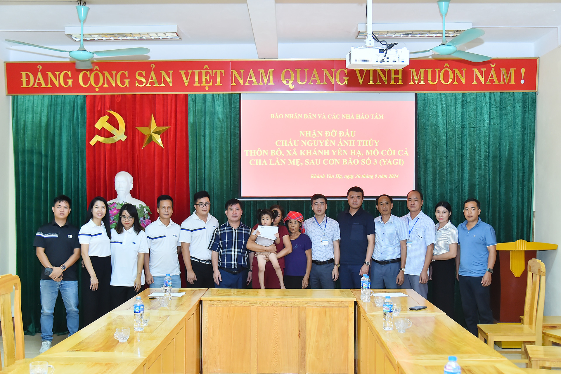 Đoàn công tác Báo Nhân Dân cùng các doanh nghiệp, nhà hảo tâm và lãnh đạo xã Yên Khánh Hạ (huyện Văn Bàn) tại buổi lễ nhận đỡ đầu cháu Nguyễn Ánh Thủy.