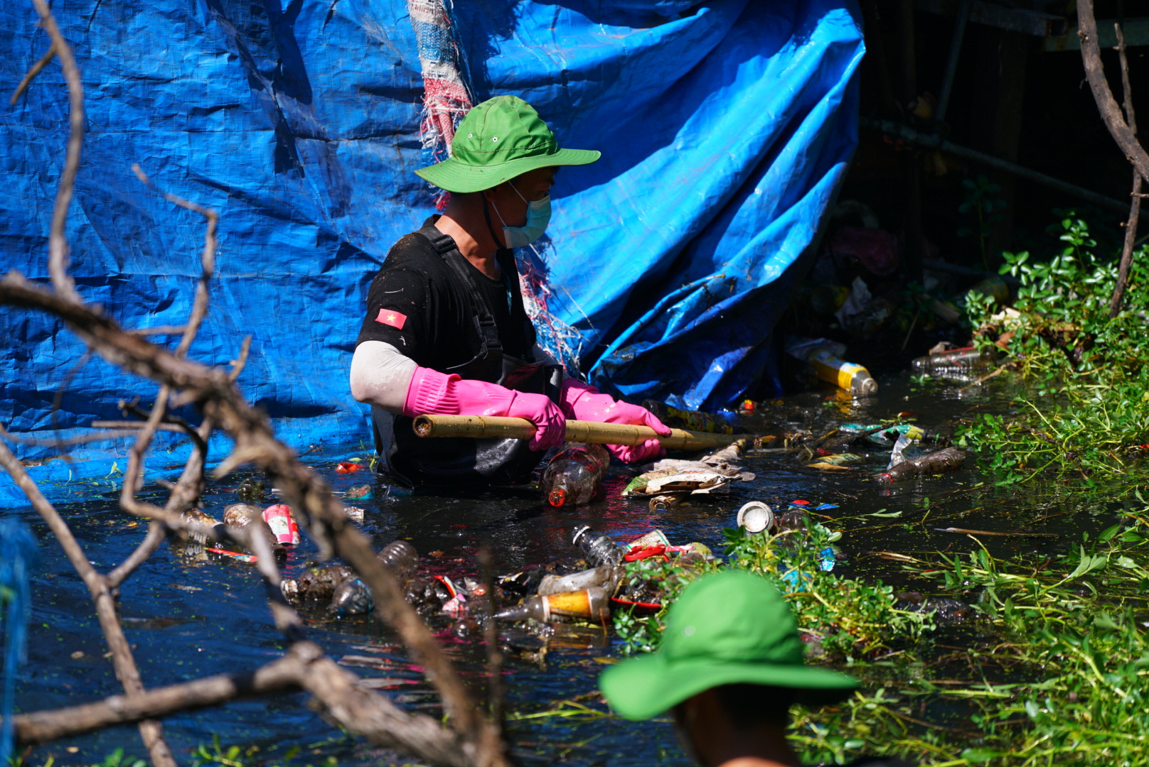 Để công việc dọn rác được thực hiện trơn tru, các thành viên phân thành 2 tổ, một tổ gồm các bạn nam sẽ trực tiếp xuống lòng ngòi hôi thối để cào rác, hốt rác, kéo rác lên bờ.