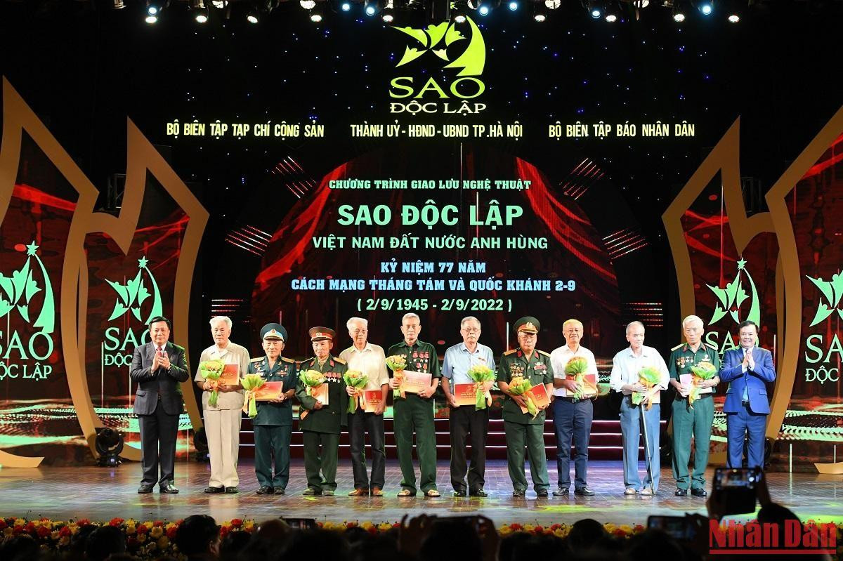 Ủy viên Bộ Chính trị, Giám đốc Học viện Chính trị quốc gia Hồ Chí Minh Nguyễn Xuân Thắng và Ủy viên Bộ Chính trị, Bí thư Thành ủy Hà Nội Đinh Tiến Dũng trao quà tặng các bậc lão thành cách mạng. (Ảnh: THÀNH ĐẠT)