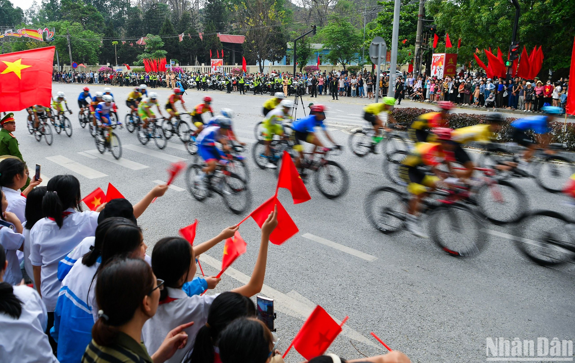 Các em học sinh vẫy cờ cổ vũ nhiệt tình cho các cua-rơ.