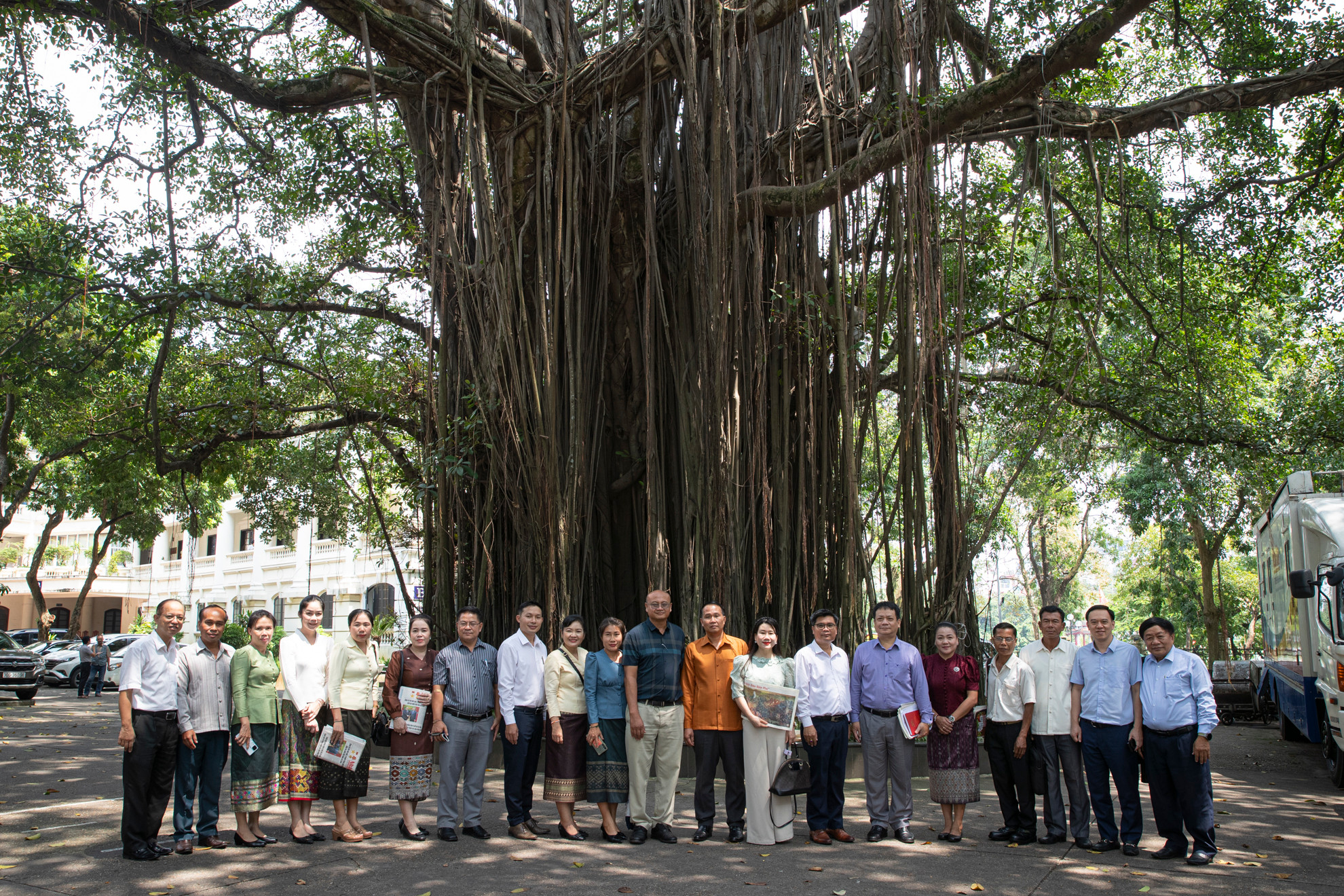 Các đại biểu chụp ảnh lưu niệm dưới gốc đa cổ thụ trong khuôn viên Báo Nhân Dân.