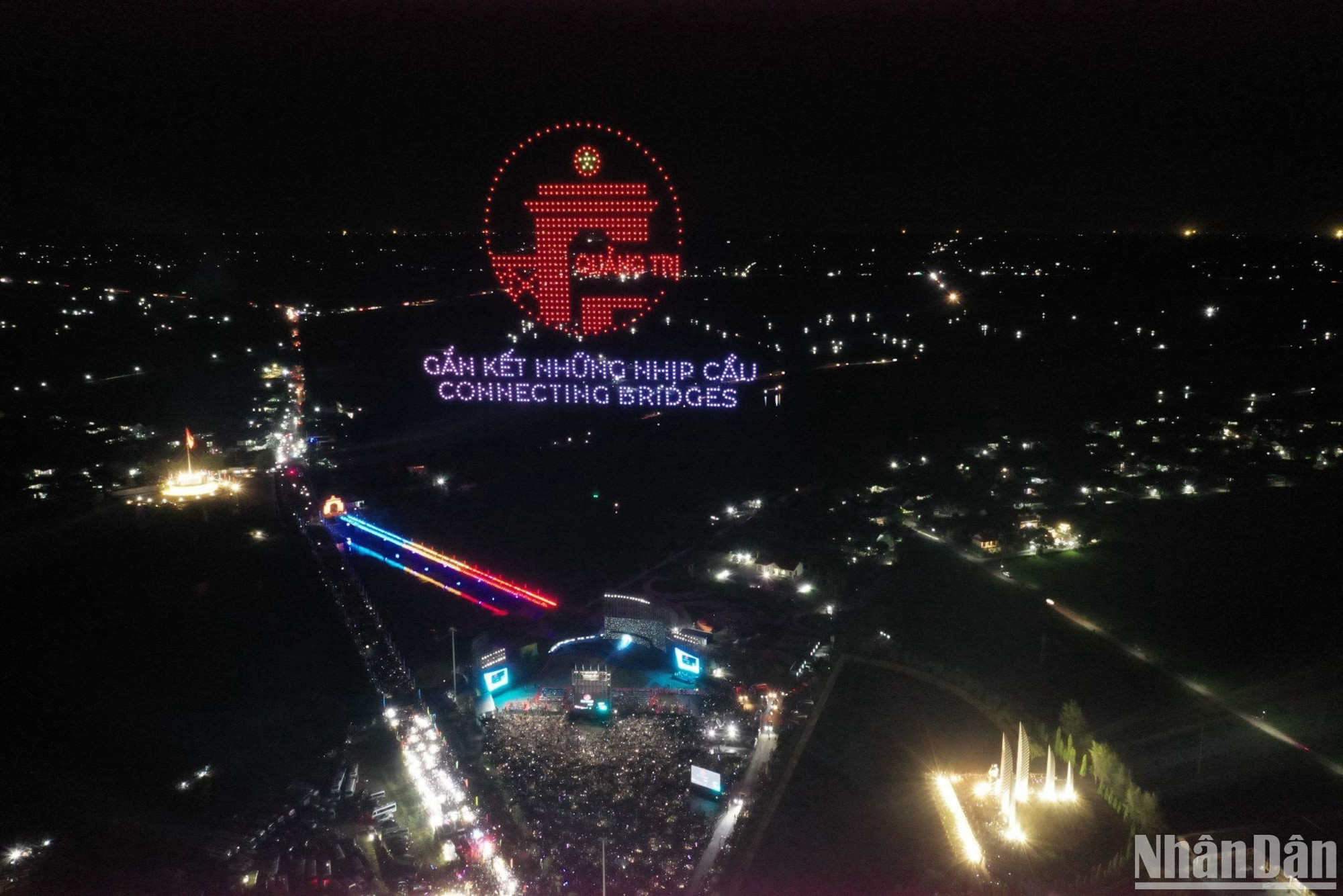 Drone light vẽ biểu tượng logo Quảng Trị và tên chủ đề chương trình "Gắn kết những nhịp cầu - Connecting bridges" trên bầu trời sông Bến Hải.