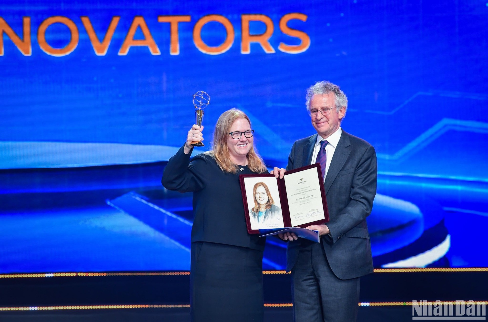 Giáo sư Richard Henry Friend - Chủ tịch Hội đồng Giải thưởng VinFuture trao cup và chứng nhận cho Giáo sư Kristi S. Anseth, người nhận giải Đặc biệt cho Nhà khoa học nữ vì đã tạo ra những tiến bộ trong thiết kế vật liệu polymer và các phương pháp cho ứng dụng y sinh. (Ảnh: THÀNH ĐẠT)