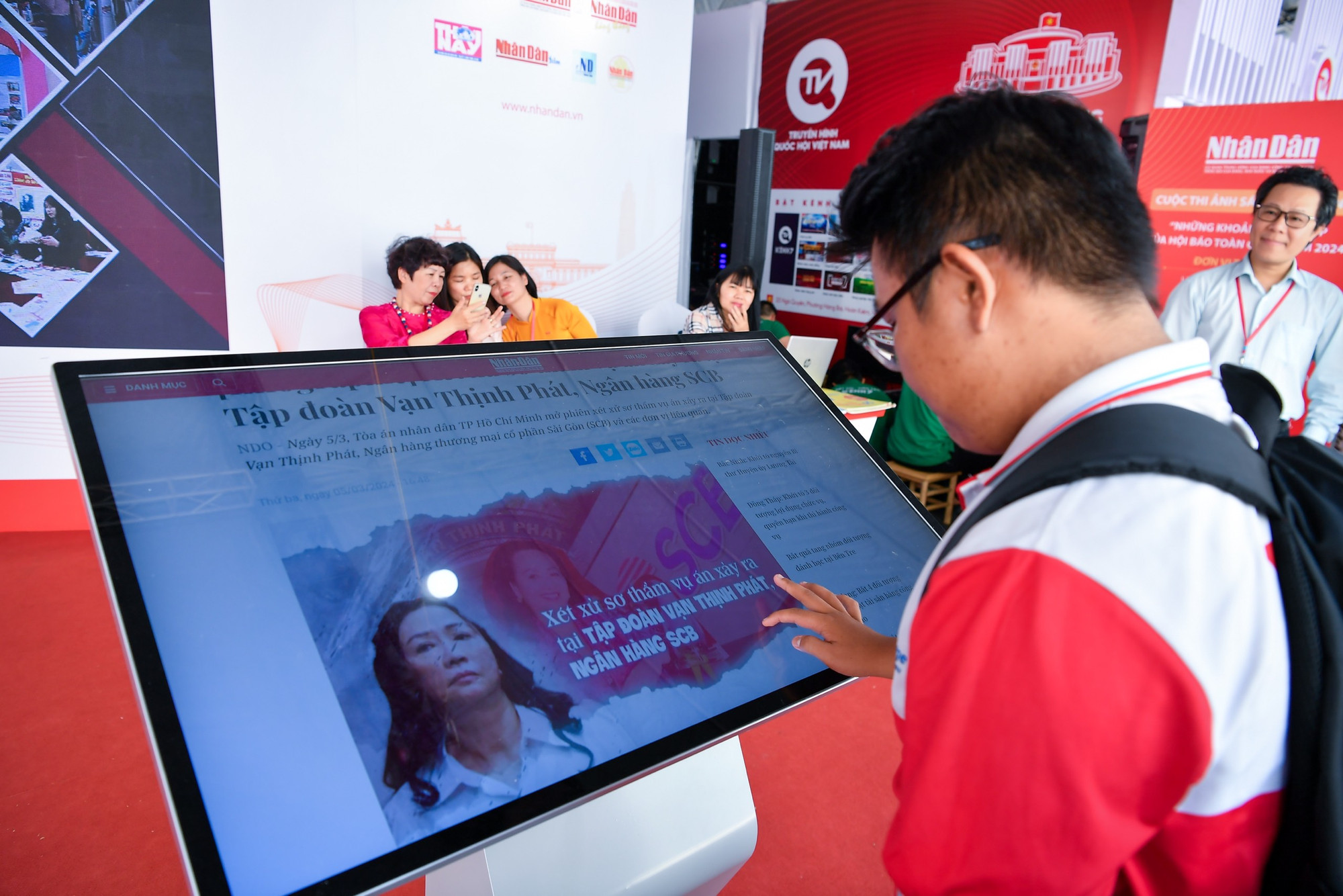 Cùng với các sản phẩm báo chí đặc sắc, nhiều ứng dụng công nghệ cũng được các cơ quan báo chí sử dụng tại gian trưng bày của mình, tạo điểm nhấn thú vị cho Hội báo năm nay. Bạn đọc "tương tác" với báo Nhân Dân điện tử qua màn hình rộng tại khu trưng bày của Báo Nhân Dân.