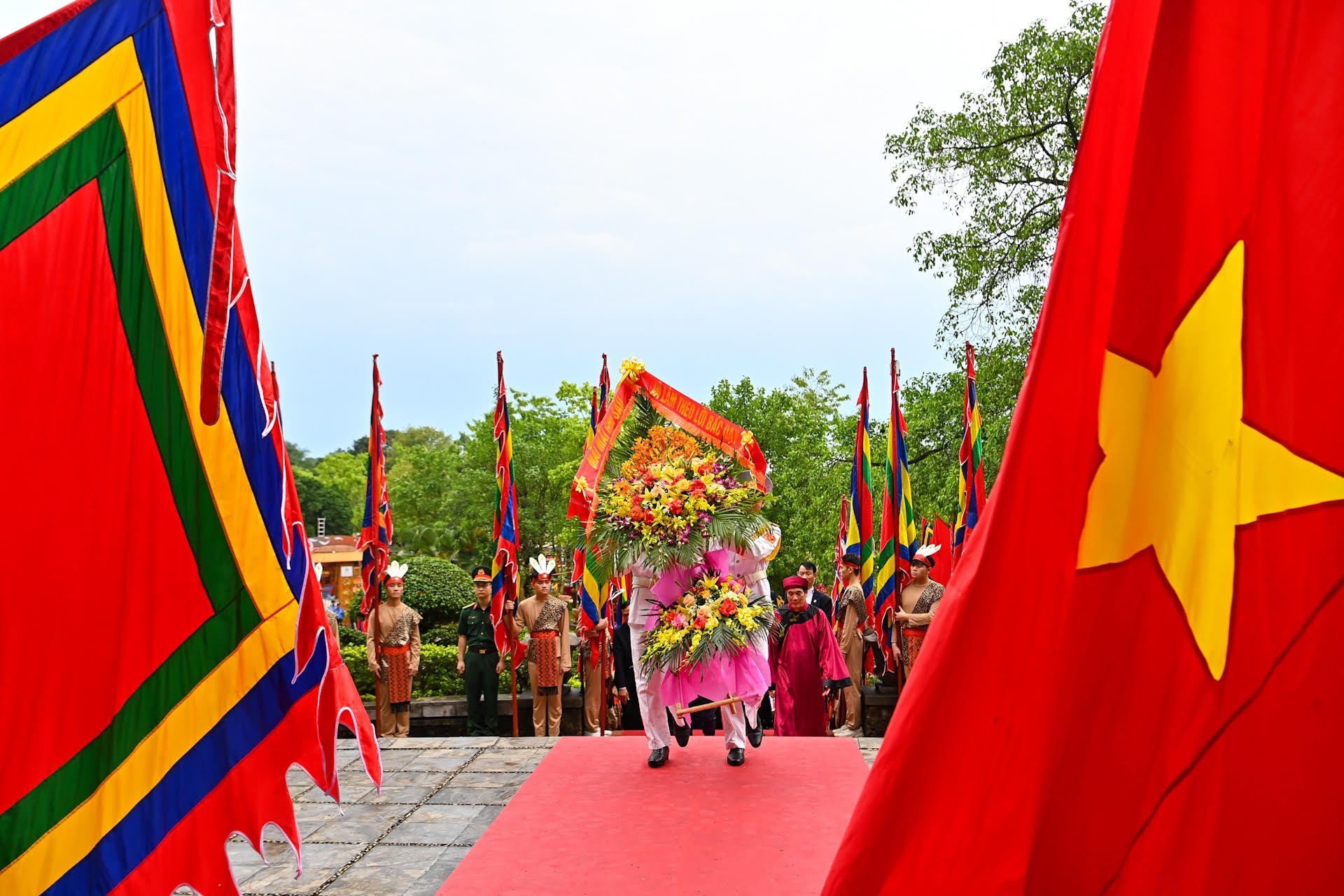 Tiếp đó, các đồng chí lãnh đạo Đảng, Nhà nước cùng các đại biểu đặt vòng hoa, thành kính tưởng niệm Chủ tịch Hồ Chí Minh và các chiến sĩ đã hy sinh vì Tổ quốc bên Bức phù điêu có hình tượng Bác Hồ nói chuyện với cán bộ, chiến sĩ Đại đoàn quân Tiên Phong tại ngã năm Đền Giếng.