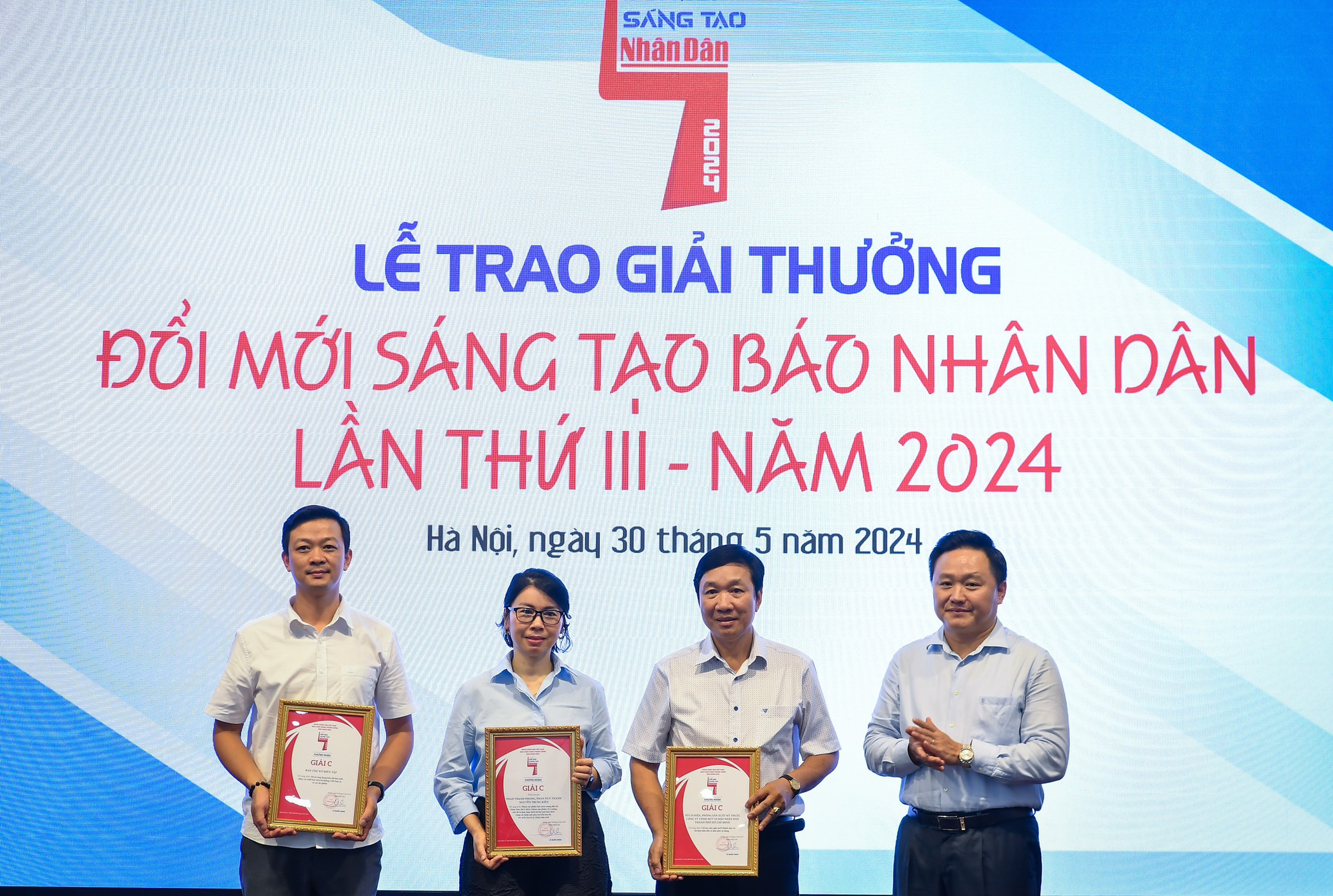 Đồng chí Phan Văn Hùng, Ủy viên Ban Thường vụ Đảng ủy, Phó Tổng Biên tập Báo Nhân Dân trao giải C cho đại diện các đơn vị, nhóm tác giả.