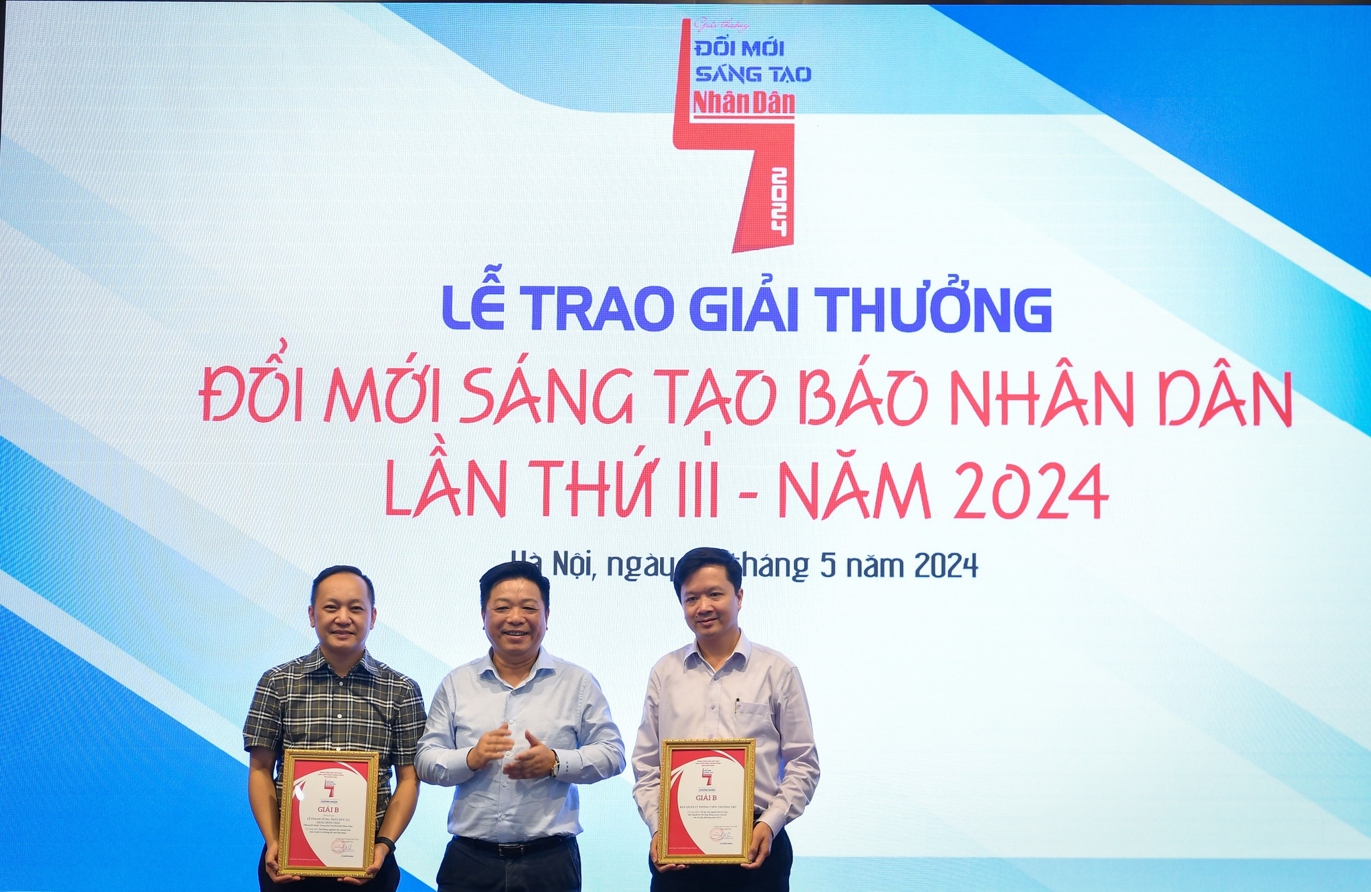 Đồng chí Quế Đình Nguyên, Phó Bí thư Đảng ủy, Phó Tổng Biên tập Báo Nhân Dân trao giải B cho đại diện các đơn vị, nhóm tác giả.