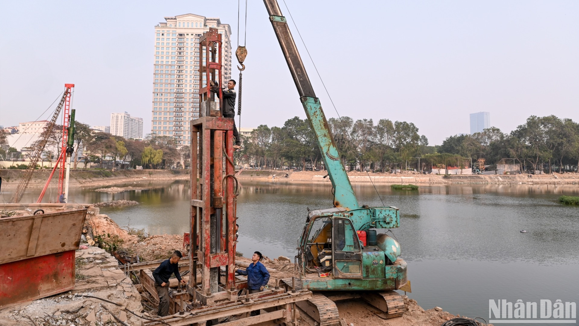 Đơn vị thi công đang ép cọc bê-tông để xây trụ cầu đi bộ trong công viên.