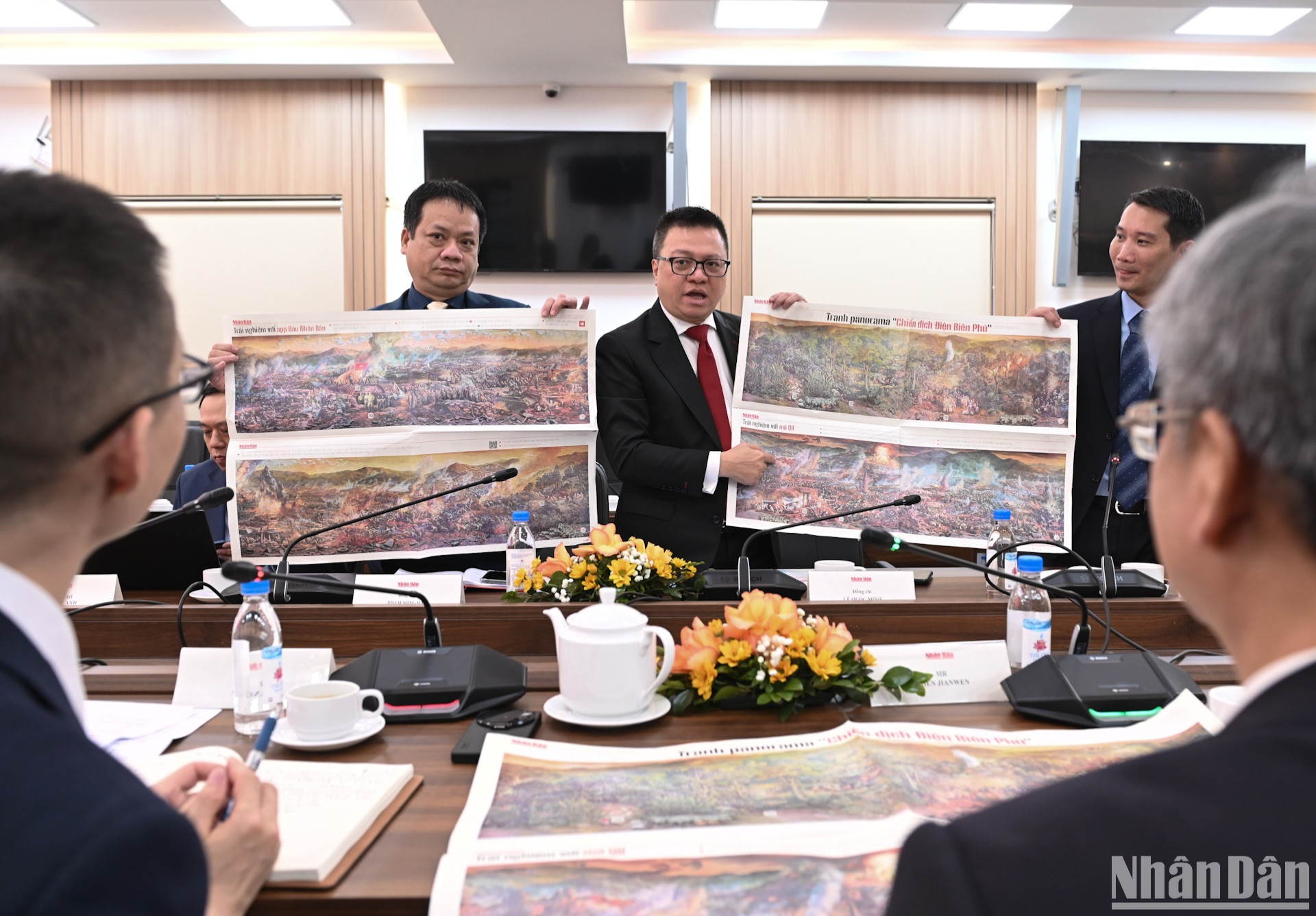 Đồng chí Lê Quốc Minh giới thiệu với đồng chí Trần Kiến Văn phụ trương in tranh panorama "Chiến dịch Điện Biên Phủ".