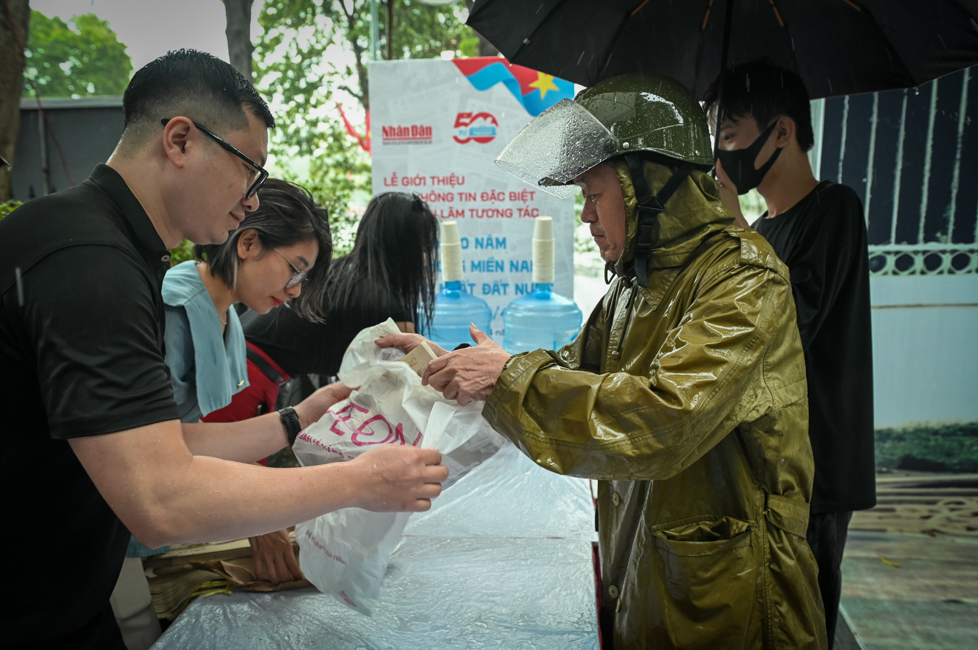 Độc giả mặc áo mưa xếp hàng đến nhận phụ san đặc biệt. Độc giả mặc áo mưa xếp hàng đến nhận phụ san đặc biệt.