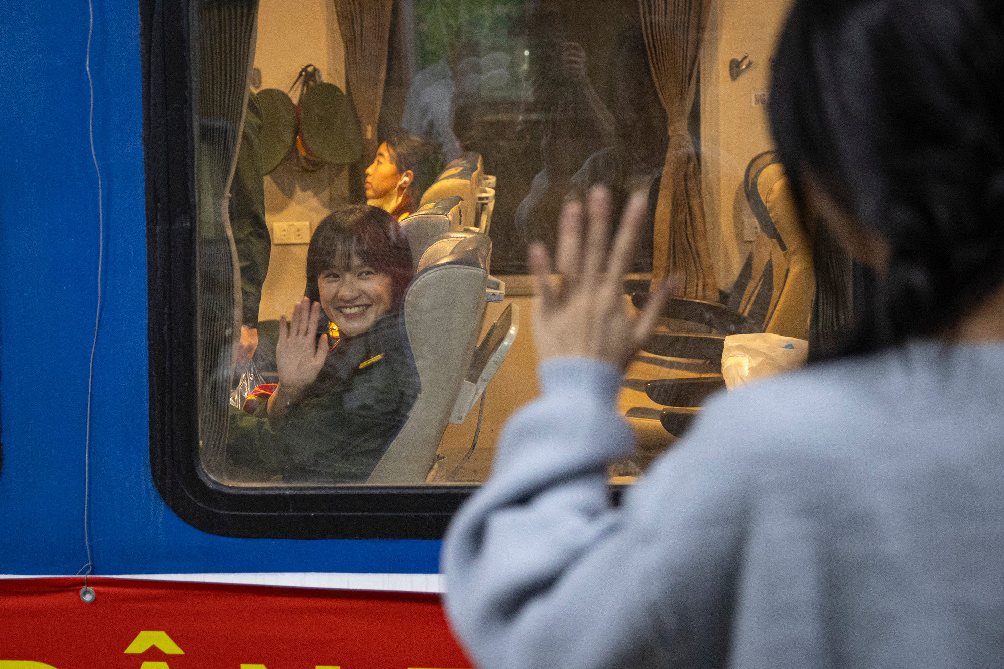 Người thân chào tạm biệt các chiến sĩ qua khung cửa sổ tàu hỏa.