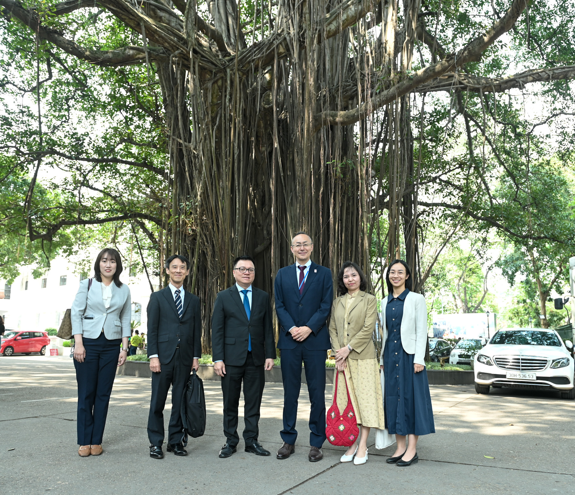Các đại biểu chụp ảnh lưu niệm dưới gốc đa cổ thụ trong khuôn viên Báo Nhân Dân.