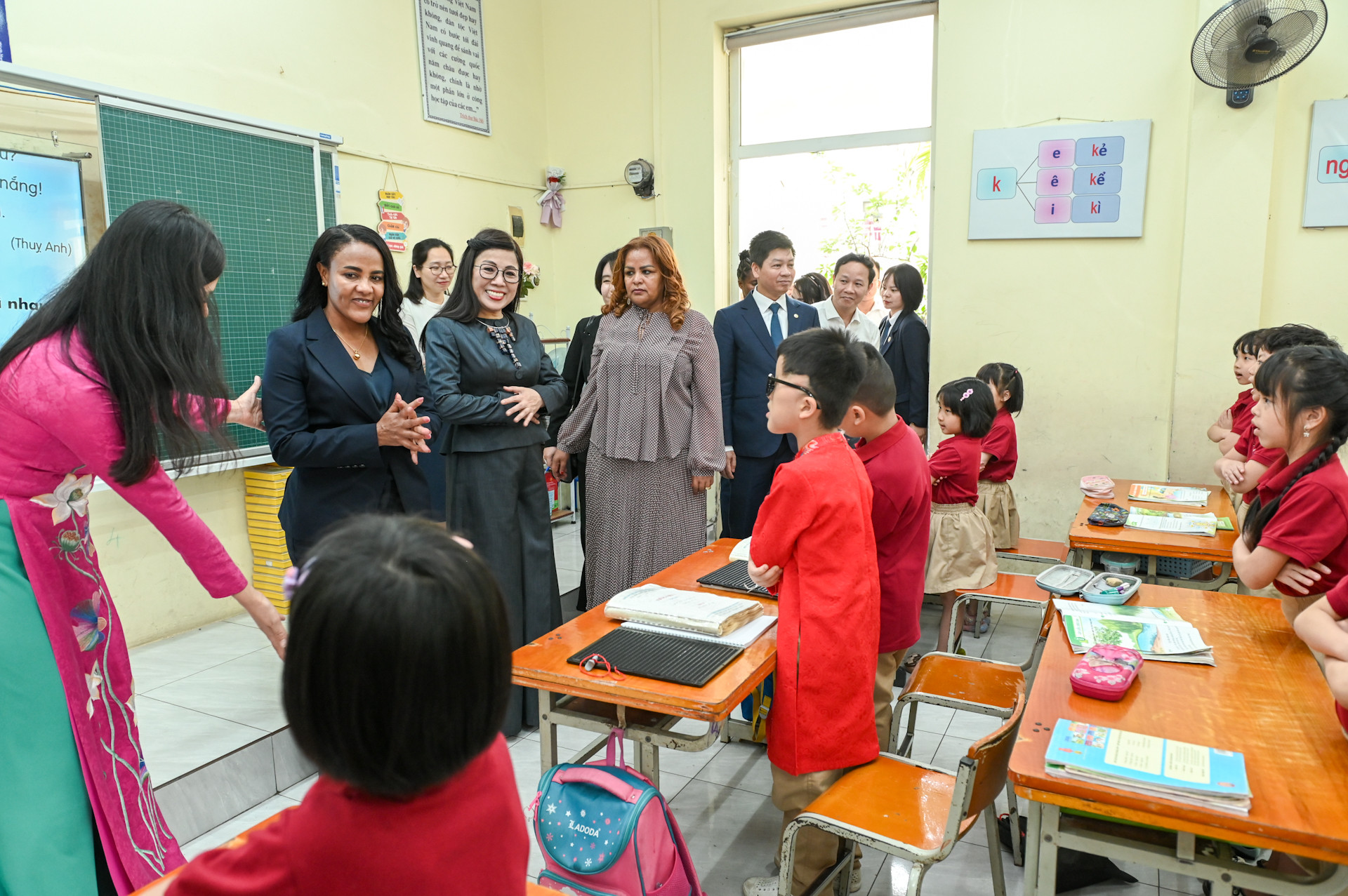 Hai phu nhân tham quan và giao lưu cùng các em học sinh tại một lớp học.