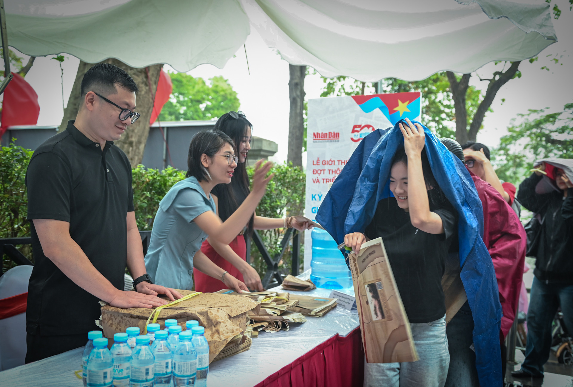 Cơn mưa bất chợt nhưng lượng người đến nhận phụ san đặc biệt và tham quan triển lãm vẫn rất đông. Cơn mưa bất chợt nhưng lượng người đến nhận phụ san đặc biệt và tham quan triển lãm vẫn rất đông.