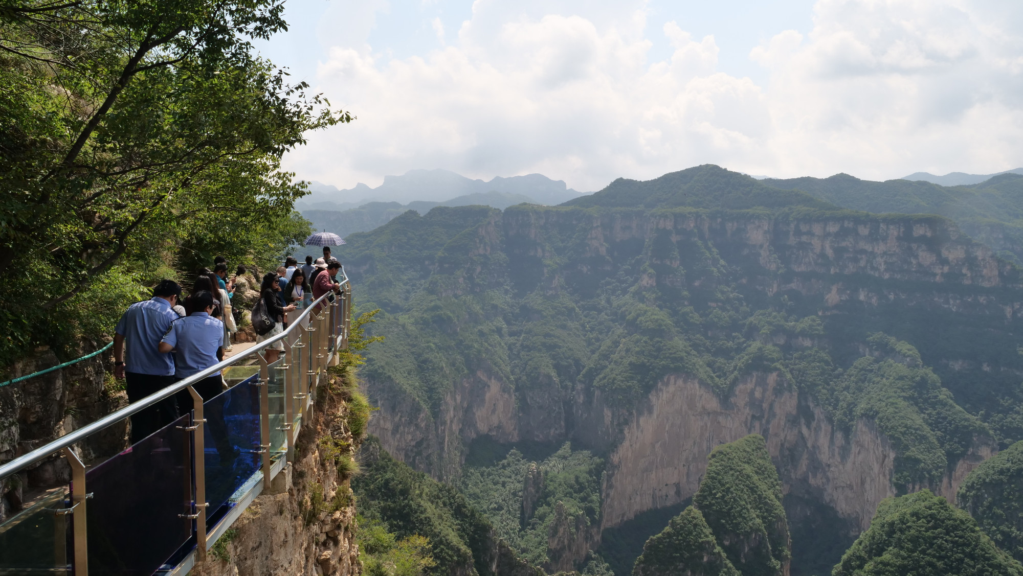 Du khách trải nghiệm đi trên cầu kính để ngắm nhìn thung lũng sâu hàng trăm mét.