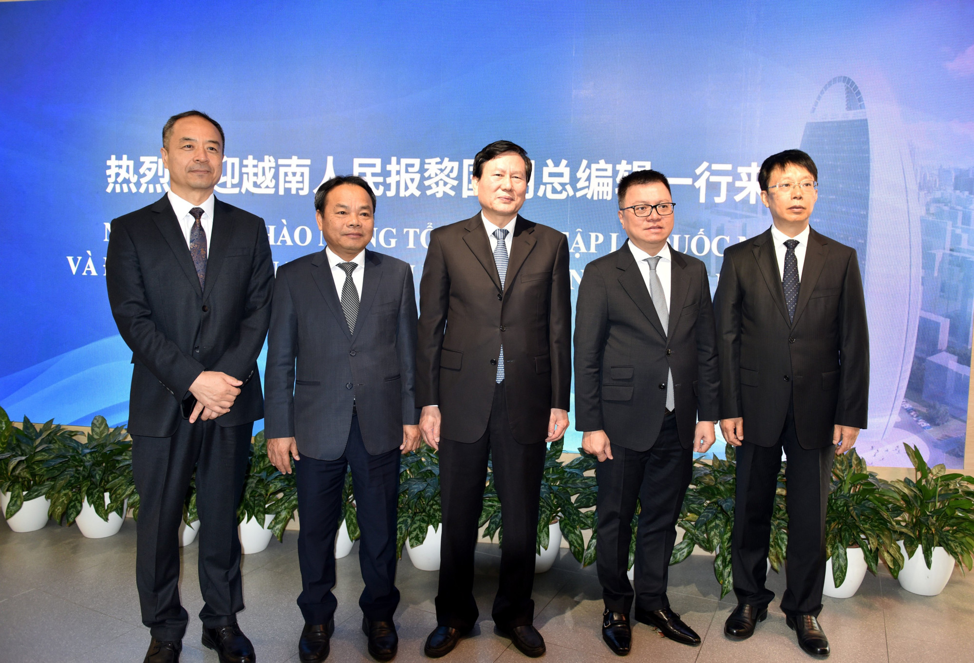 Lãnh đạo hai bên chụp ảnh lưu niệm. Trong ảnh, từ phải sang trái, lần lượt là Tổng Biên tập Nhân dân nhật báo Vu Thiệu Lương, Tổng Biên tập Báo Nhân Dân Lê Quốc Minh, Xã trưởng Nhân dân nhật báo Đà Chấn, Phó Tổng Biên tập Báo Nhân Dân Đinh Như Hoan và Phó Tổng Biên tập Nhân dân nhật báo Thôi Sỹ Tân.