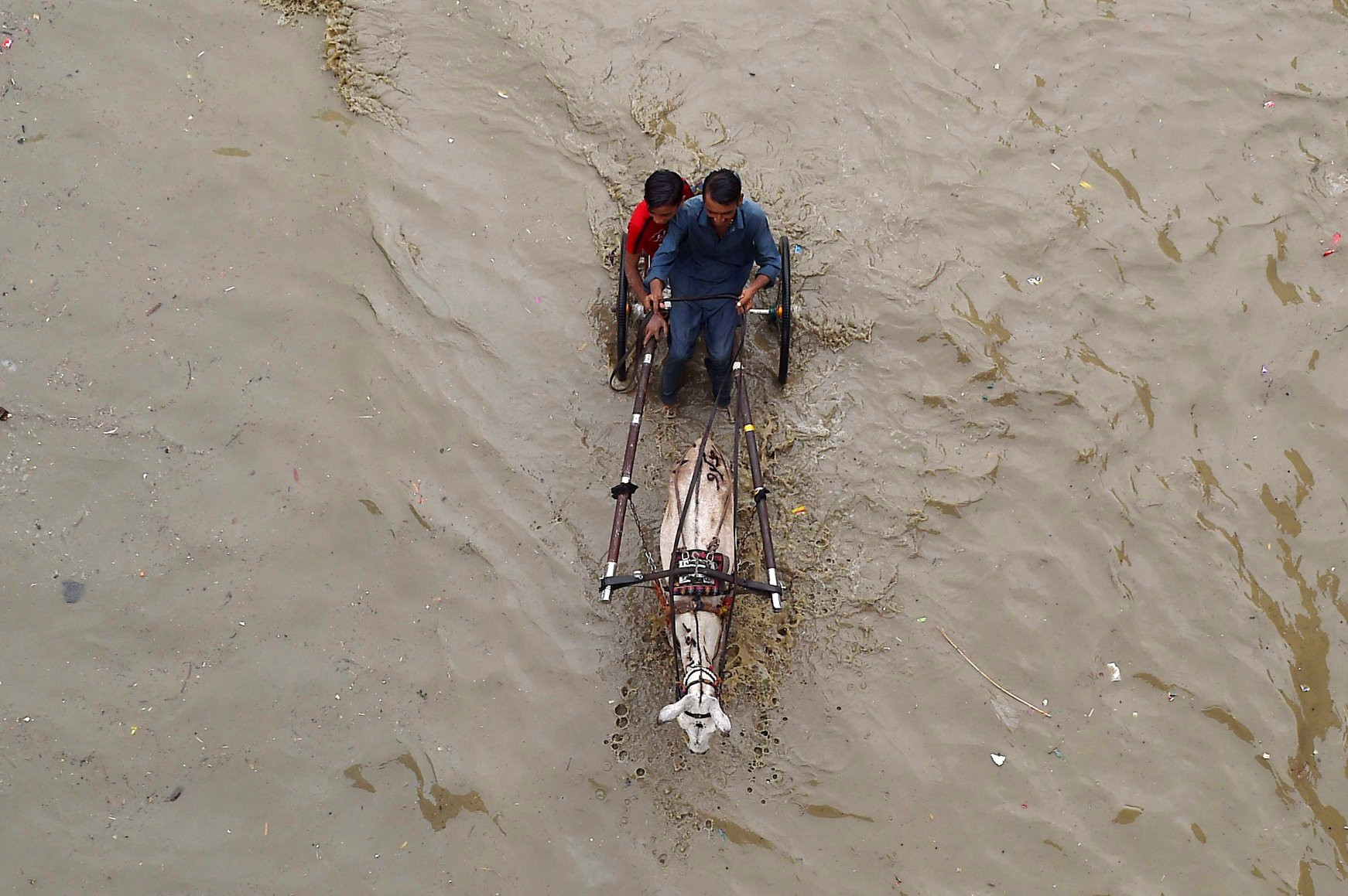 Người dân đi qua con đường bị ngập sau các cơn mưa lớn ở Karachi, Pakistan ngày 24/7. Ảnh: EPA.