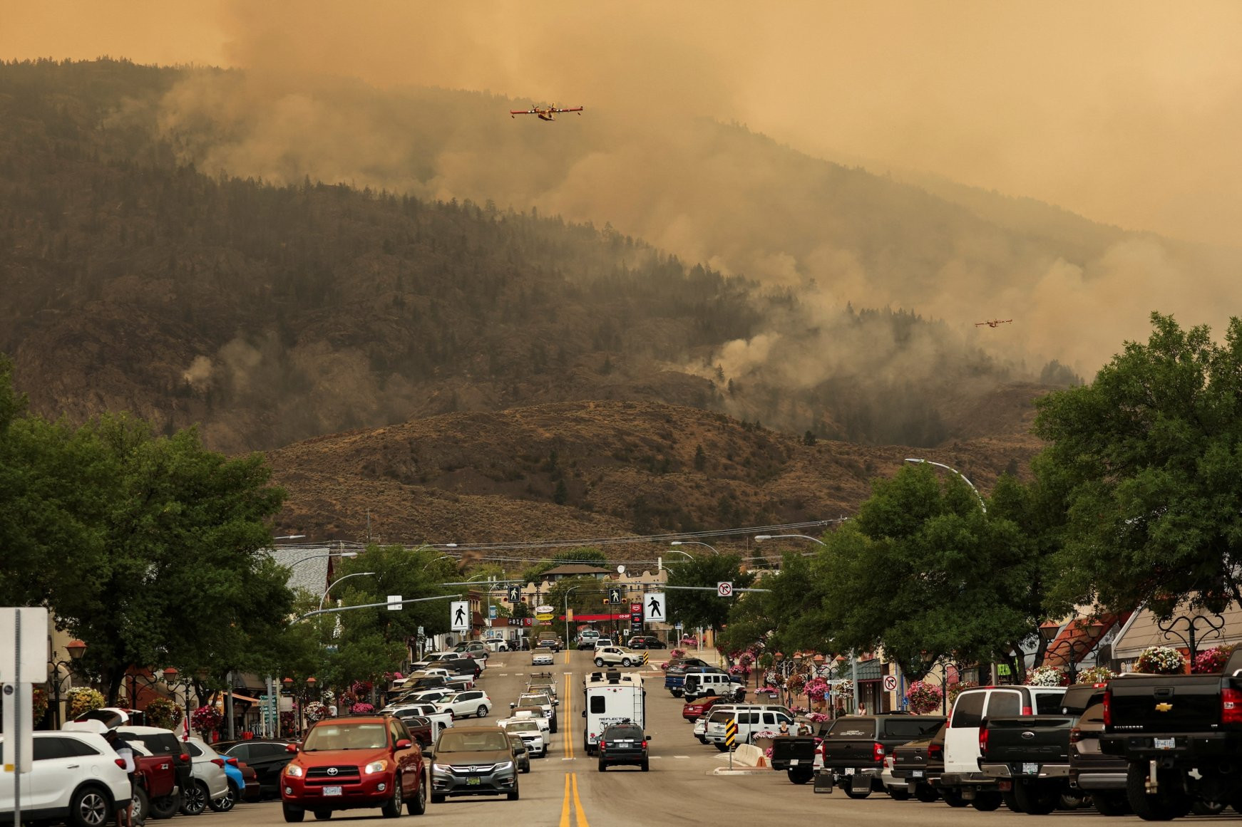 Máy bay cứu hỏa nỗ lực dập đám cháy rừng Eagle Bluff sau khi nó lan qua biên giới Canada-Mỹ từ bang Washington và có lệnh sơ tán ở Osoyoos, British Columbia, Canada vào ngày 30/7. Ảnh: Reuters.