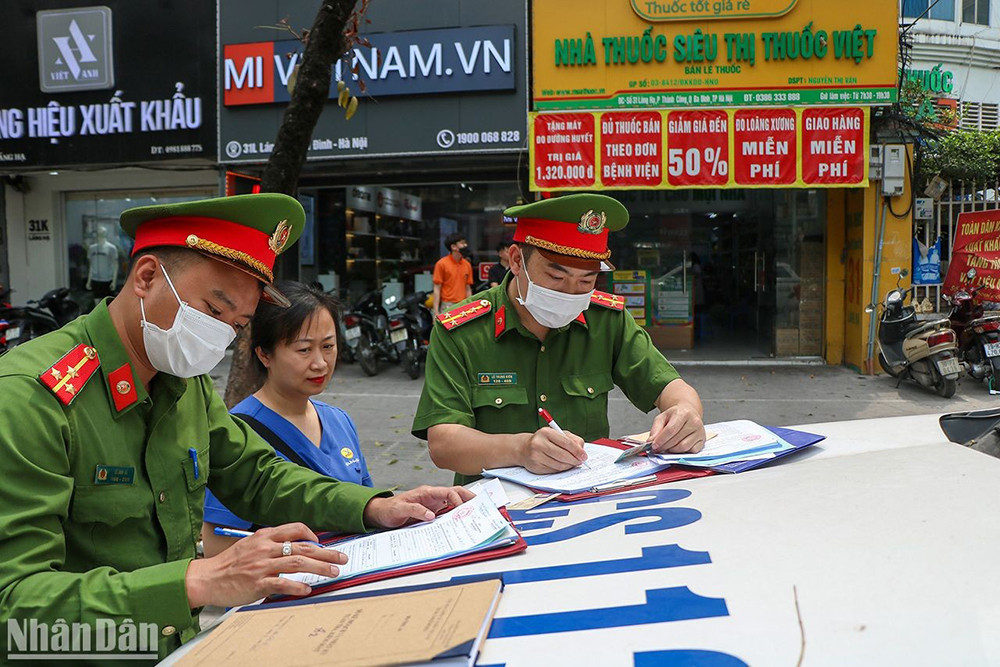 Công an phường Thành Công xử phạt chủ xe ô-tô để không đúng quy định. (Ảnh: Nhật Quang)