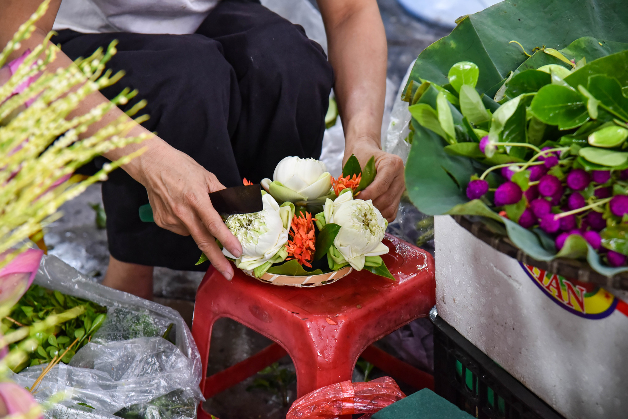 Một tiểu thương đang tất bật, tỉ mẩn chuẩn bị mâm hoa quả cho khách. Trên mâm thường có những loại hoa như hoa sen, hoa cau, hoàng lan, bách hợp... Một tiểu thương đang tất bật, tỉ mẩn chuẩn bị mâm hoa quả cho khách. Trên mâm thường có những loại hoa như hoa sen, hoa cau, hoàng lan, bách hợp...