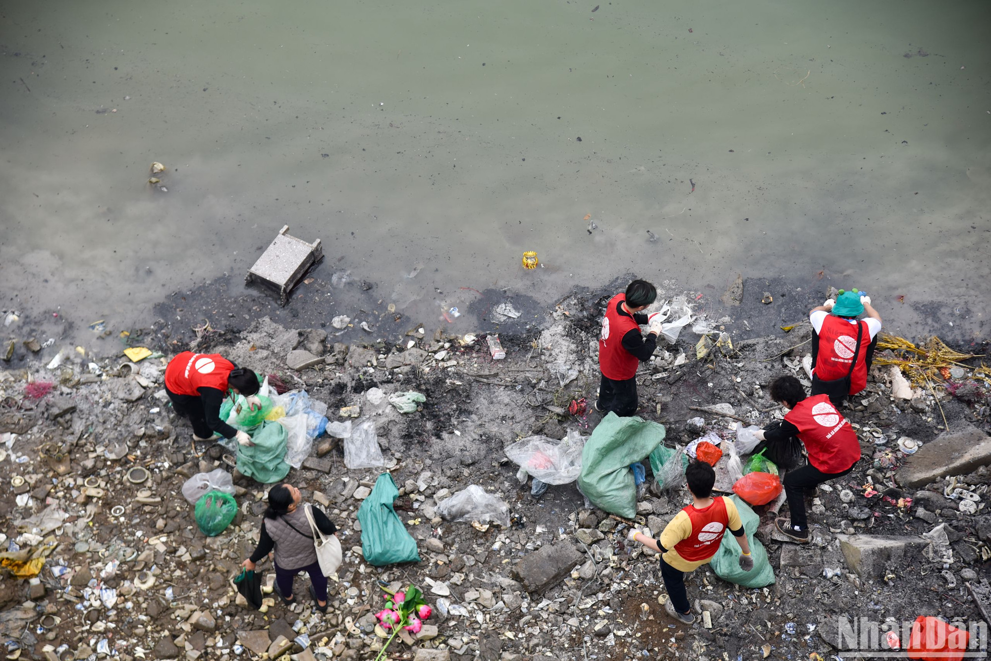 Ở phía dưới bờ sông Hồng, các bạn tình nguyện viên vẫn miệt mài thu gom và dọn dẹp rác thải, túi nilon.