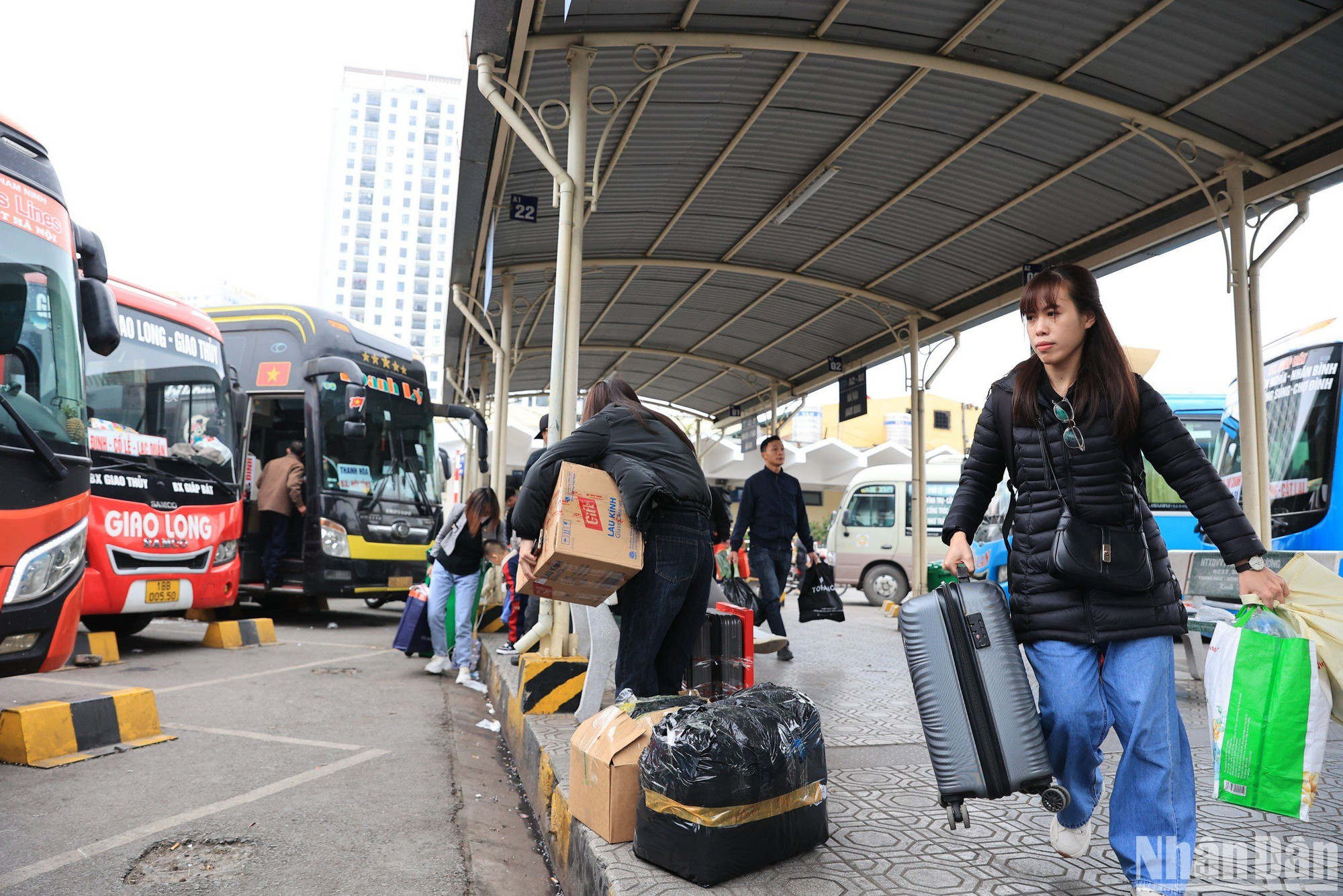 Một cô gái tay xách nách mang, vội vàng lên chuyến xe để kịp đón Tết cùng người thân và gia đình.