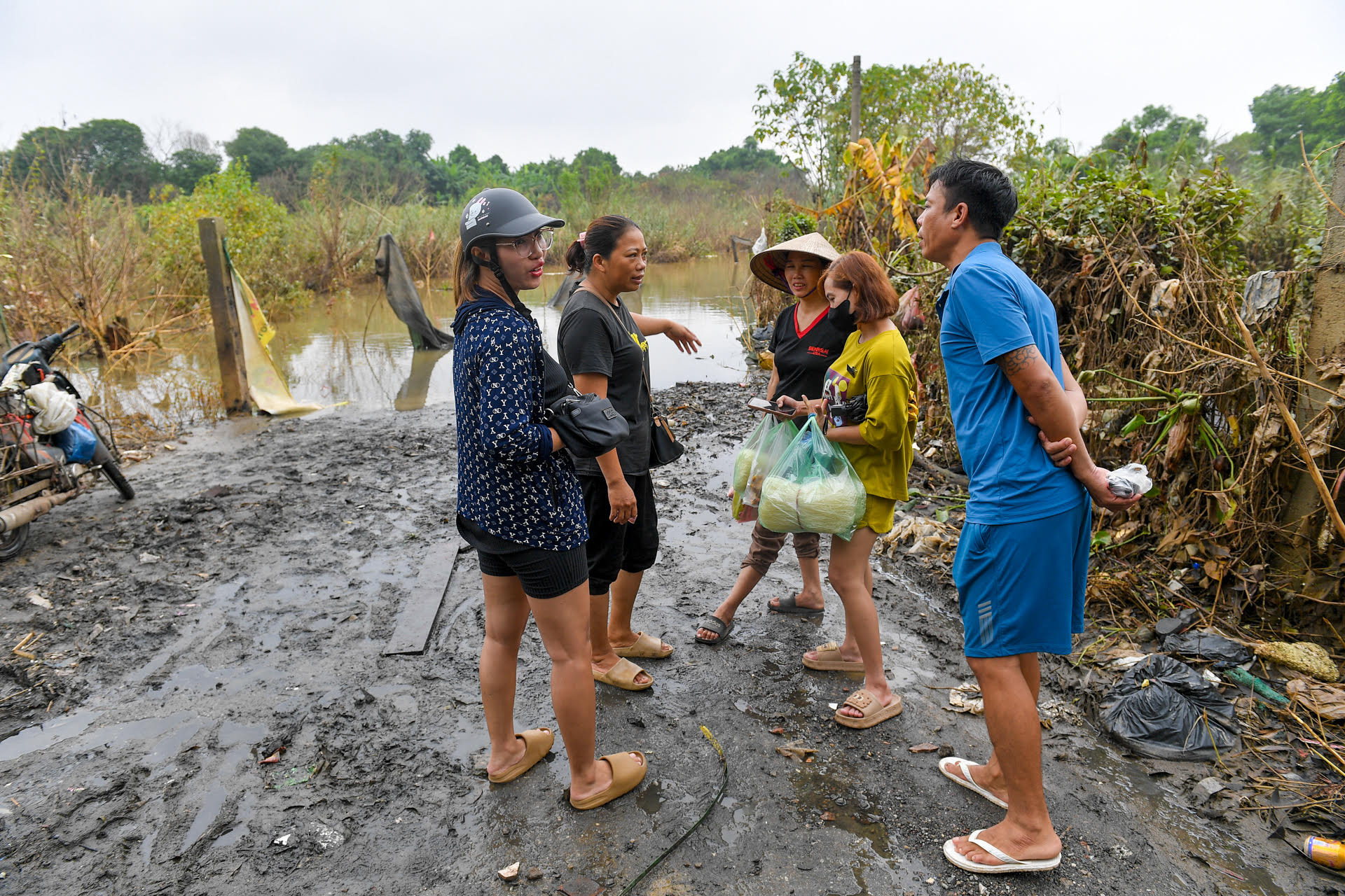Đường đi xuống đầy bùn lầy, người dân phải để những tấm ván nhỏ để đi lại.