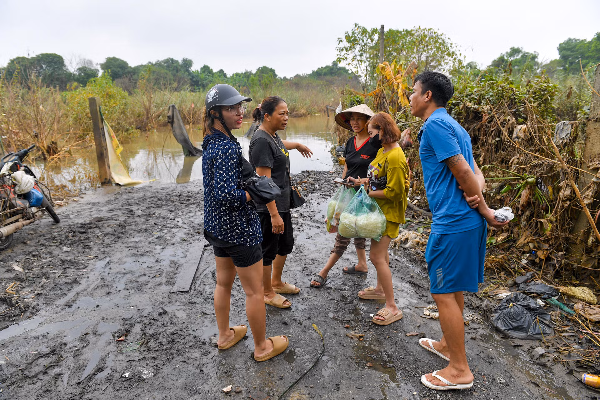 Đường đi xuống đầy bùn lầy, người dân phải để những tấm ván nhỏ để đi lại.