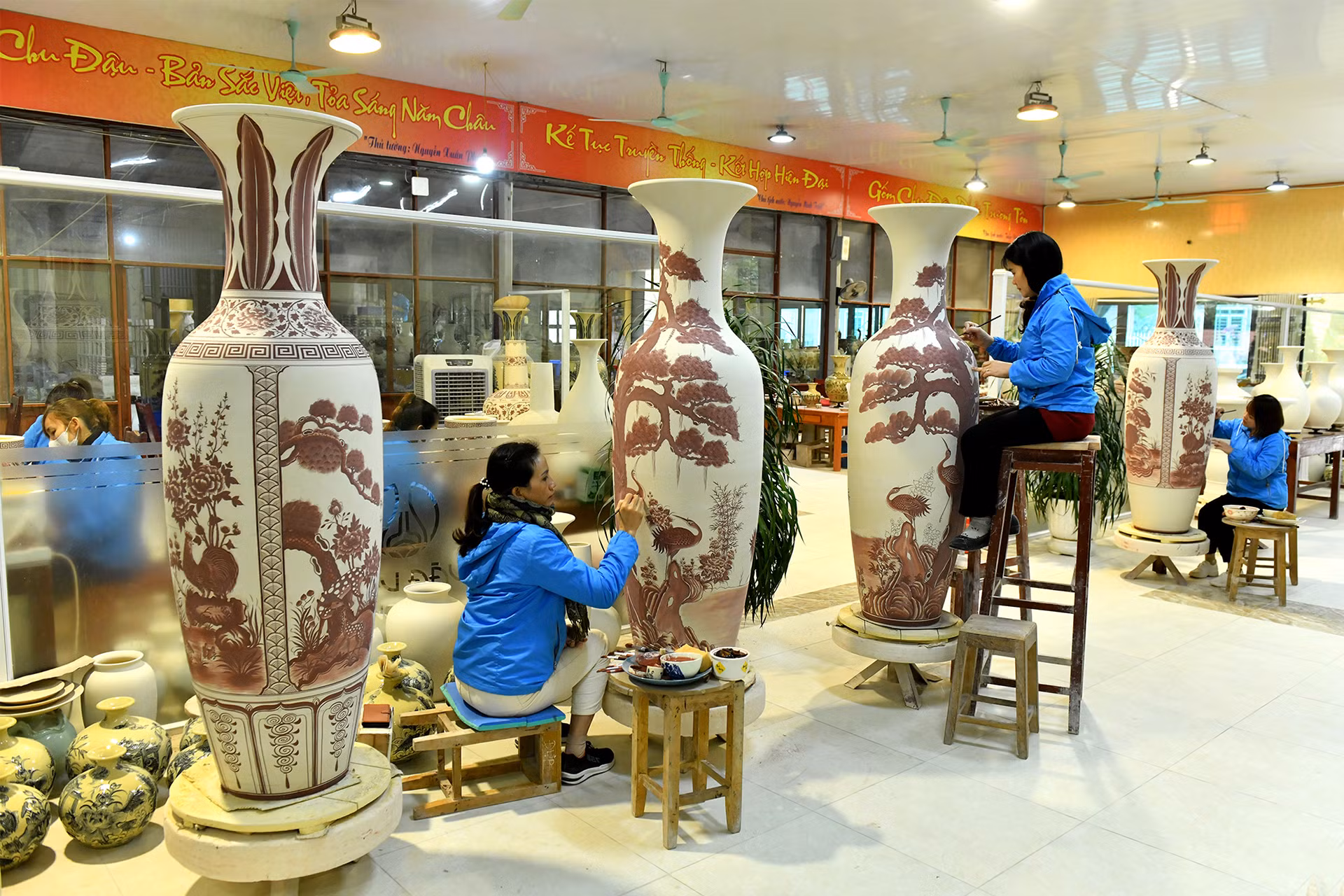 Nghệ nhân vẽ hoa văn lên bình gốm có kích cỡ lớn.