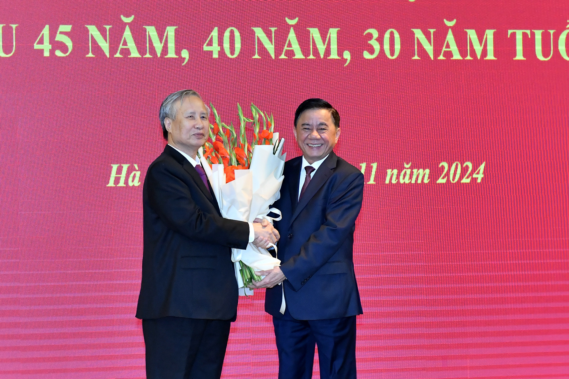 Đồng chí Trần Cẩm Tú, Ủy viên Bộ Chính trị, Thường trực Ban Bí thư, Chủ nhiệm Ủy ban Kiểm tra Trung ương tặng hoa chúc mừng đồng chí Trần Quốc Vượng.