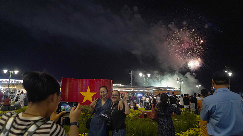 Nhiều người phấn khởi dùng điện thoại ghi lại những khoảnh khắc pháo hoa sáng rực trên bầu trời thành phố.