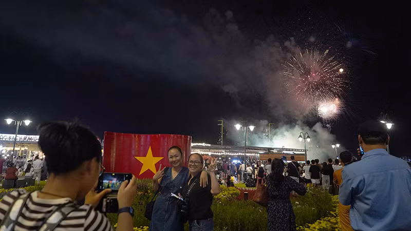 Nhiều người phấn khởi dùng điện thoại ghi lại những khoảnh khắc pháo hoa sáng rực trên bầu trời thành phố.