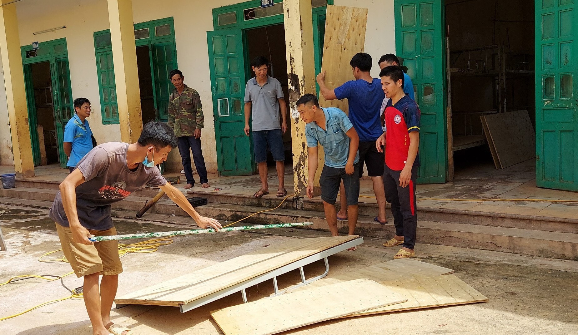 Các thầy giáo và phụ huynh học sinh hỗ trợ sửa giường cho học sinh nội trú Trường Phổ thông dân tộc bán trú Trung học cơ sở Mường Nhé (huyện Mường Nhé, tỉnh Điện Biên).